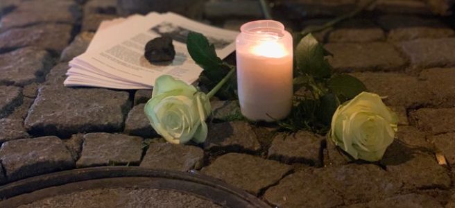 Zwei weiße Rosen, eine Kerze und die Broschüren über Familie Frischmann vor ihrem ehemaligen Wohnhaus am 10. November 2022